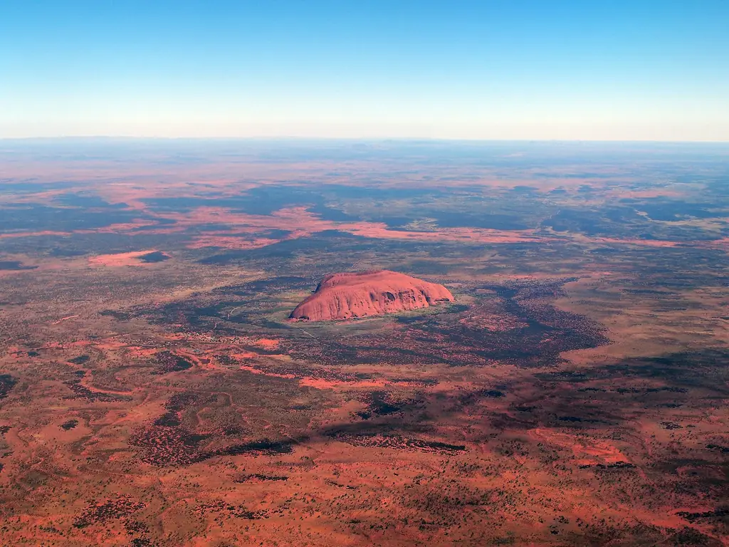 Aerial view of Uluru from a scenic flight over the surrounding red sand plain