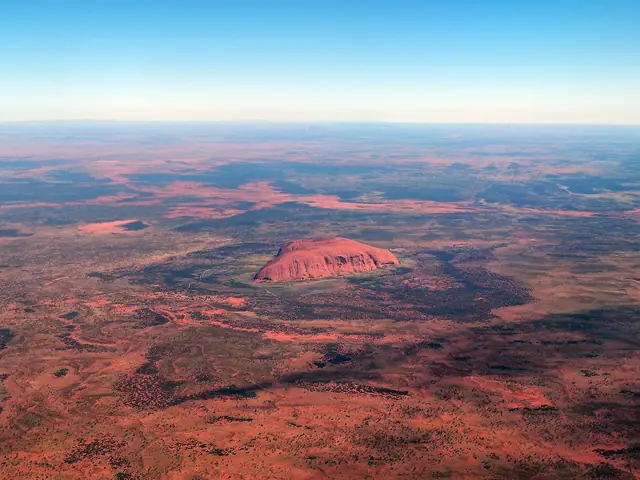 Aerial view of Uluru from a scenic flight over the surrounding red sand plain