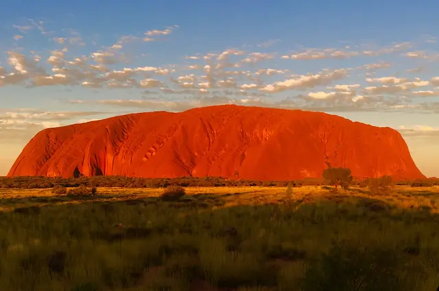 Uluru glowing deep orange at sunset in Uluru-Kata Tjuta National Park